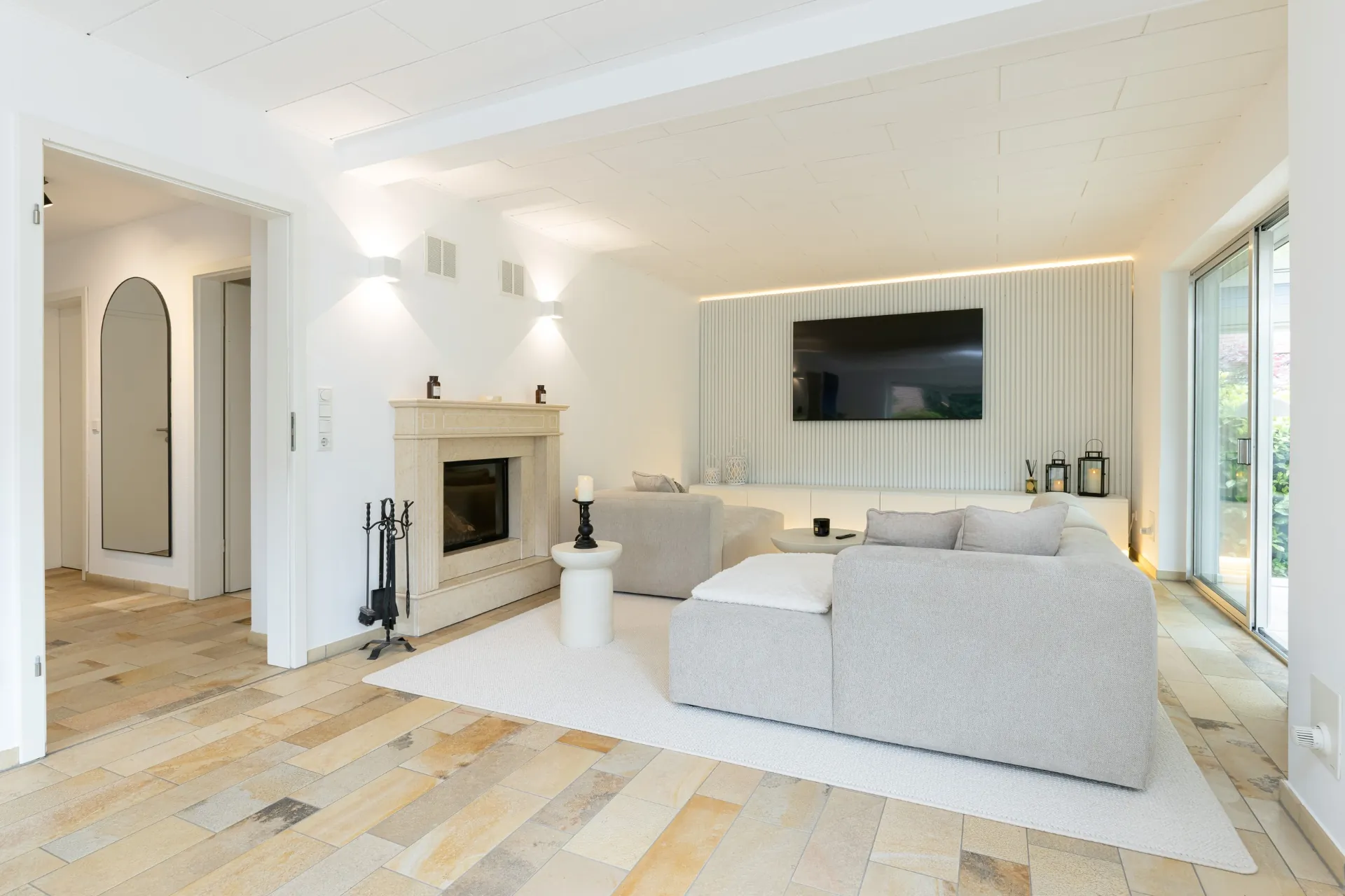 Heller Wohnbereich mit Kamin und Designer-Sofa im Ferienhaus Smukke in Hattstedt